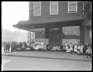 Kinderen poseren voor een onbekende vestiging van de Queens Borough Public Library, New York, ca. 1910