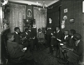 Evangelistencomitéles bij mevrouw Bostick, 72 West 99th Street, de heer Rockwood geeft les aan een groep jonge Afro-Amerikaanse mannen en jongens. 31 maart 1916