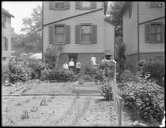 Familie poseert naast hun moestuin in de achtertuin, Inwood, New York, ca. 1910