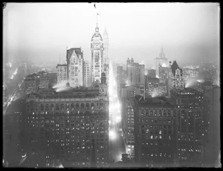 Hooghoekige mistige nachtzicht van lager Manhattan naar het noorden, met het Singer Building, Woolworth Building en Municipal Building zichtbaar, c.1913