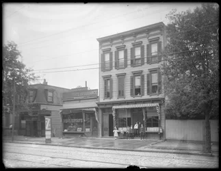 Zeven kinderen poseren voor een niet-geïdentificeerde tak van de Queens Borough Public Library, New York, ca. 1910