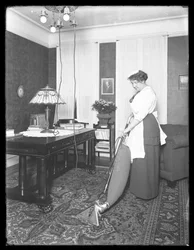 Onbekende vrouw die het gebruik van de Apex-stofzuiger demonstreert, ca. 1913-14
